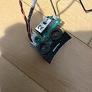 Fotografie znázorňuje elektronický předzesilovač s dvěma černými oválnými ovladači. Na černém plastovém krytu je bílý nápis FISHMAN a na vnitřní část…