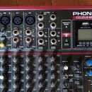 Míchací pult červené barvy s černým ovládacím panelem a nápisem PHONIC CELEUS 600. Zařízení obsahuje několik vstupních kanálů s konektory XLR, potenc…