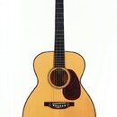Akustická kytara s přirozenou světlou barvou korpusu a tmavým hmatníkem. Na hlavě je nápis Cougar. Tělo má hnědý trsaný pickguard a tmavý most s bílý…