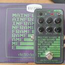 Šedý efekt pedál s nápisy MAINFRAME, bit crusher a značkou electro-harmonix NEW YORK CITY, USA. Zařízení má pět černých otočných ovladačů s popisky V…