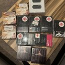 Fotografie zobrazuje sadu kytarových snímačů v originálních krabicích a obalech. Jsou zde vidět produkty značek Bare Knuckle PICKUPS s označením WARP…