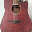 Akustická kytara s vyřezem v korpusu, provedená v tmavě červené barvě s viditnou strukturou dřeva. Na hmatníku je vidět nápis "Gretsch". Pod otvorem…