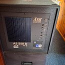 Černý akustický subwoofer značky AER s nápisem Audio Electric Research the acoustic people. Na zadním panelu je uveden model AS 550 D a přepínač mezi…