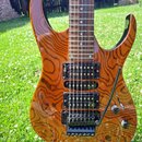 Elektrická kytara s tělem z dřeva s výraznou žlutohnědou sletovanou strukturou. Nástroj má dva snímače typu humbucker, jeden potenciometr a přepínač.…