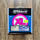 Fotografie znázorňuje obal na struny do basové kytary značky D'Addario. Na černé horní části je bílý nápis D'Addario a pod ním Coated Bass Strings. M…