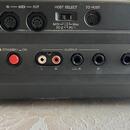 Záběr na zadní panel černého elektronického hudebního nástroje s různými konektory. V horní části jsou vstupy a výstupy s nápisy SUSTAIN, IN — MIDI —…