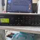 Černý rackový procesor s nápisem Fractal AUDIO SYSTEMS a Axe-Fx ULTRA PRE-AMP / EFFECTS PROCESSOR. Zařízení má digitální displej, několik tlačítek a…