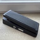 Černý efekt pedál s žebrovaným horním povrchem. Na boku je uveden nápis "AMPLIFIER" a na horní hraně nápis "Sustain". Na spodní části je vidět značka…