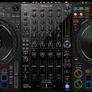 Černý DJ kontrolér s dvěma velkými jog-koly a centrálním mixážním sekcí. Na horní hraně je nápis Pioneer DJ a v dolní části označení DDJ-FLX10. Zaříz…