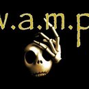 Fotografie zobrazuje grafiku na černém pozadí. V horní části je žlutý nápis „w.a.m.p.“. Pod nápisem je zobrazen lebka s kostnatou rukou, která ji zak…