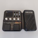Černý kytarový procesor s výrazným logem NUX na pravé části. Na přístroji je nápis MG-101 MODELING GUITAR PROCESSOR, dále označení TS/AC HD CORE IMAG…