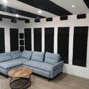 Interiér místnosti s bílými stěnami a světlou podlahou, vybavený akustickými panely. Na stěnách a stropě jsou umístěny černé absorbenty s vlnovitým p…