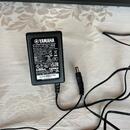 Černý síťový adaptér značky YAMAHA s modelem PA-130B. Na štítku jsou uvedeny technické parametry, certifikace a nápis MADE IN KOREA 2012/03 BY FX. Ad…