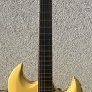 Žlutá elektrická kytara s matným povrchem a tmavým hmatníkem. Nástroj má dva humbuckery, jeden ovládací knoflík a fixní most. Na hlavě ani na těle ne…