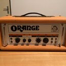 Kytarový zesilovač v oranžovém vinylovém potahu s černými ochrannými rohy a úchytkou. Na předním panelu je velký nápis ORANGE a logo s heraldickým zn…