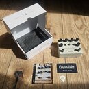 Na fotografii je efekt pedál krémové barvy s nápisy COLOSSEUM a Cornerstone MUSIC GEAR. Pedál má pět černých ovládacích knoflíků, přepínač a dva vstu…