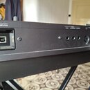 Detail zadní strany černé klaviatury s několika konektory. Jsou zde nápisy USB MEMORY, COMPUTER a PEDAL HOLD EXPRESSION CONTROL s příslušnými vstupy.…