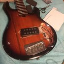 Elektrická kytara s tmavě hnědým sunburst povrchem a hnedým hmatníkem bez pražců. Na těle je instalován jeden černý humbucker a chromovaný kobylník s…