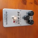 Stříbrný efekt pedál s kovovým šasi. Na povrchu jsou nápisy „electro-harmonix NEW YORK CITY, USA“, „TRIANGLE BIG MUFF“ a označení ovládacích prvků „V…