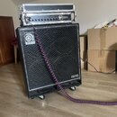 Černý basový kombozesilovač s mřížkou z kovového pletiva a nápisy Ampeg v horní části a PRO NEO v pravém dolním rohu. Na horní hraně boxu je umístěn…