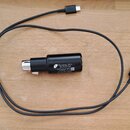 Černý kabel s konektory USB-C na obou koncích a integrovaným černým cylindrickým adaptérem. Na adaptéru je bílý text: „Shure Incorporated - Global HQ…