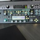 Fotografie zachycuje dvě rackové jednotky umístěné nad sebou. Horní zařízení je šedé zvukové rozhraní s nápisem apollo | x6 a logem Universal Audio.…