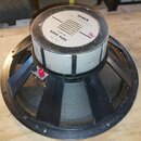 Fotografie zachycuje zadní stranu reproduktoru s černým rámem a magnetem obaleným v bílém papíru. Na štítku jsou uvedeny nápisy TESLA, MADE IN CZECHO…