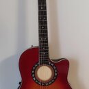 Akustická kytara s cutawayem v červeně-oranžovém sunburst provedení. Na hlavě hmatníku je nápis "Cort". Kolem otvoru rezonanční desky je dekorativní…
