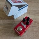 Červený efekt pedál s nápisy HALL OF FAME 2 MINI a tc electronic. Na pedálu jsou tři černé ovládací knoflíky a stisknutý nápis TRUE BYPASS nad stoupa…