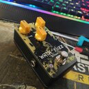 Černý efekt pedál s žlutým grafickým motivem a třemi žlutými oválnými knoflíky. Na povrchu je bílý nápis „WATA FUZZ“ a pod ním menší text „pedals“. N…