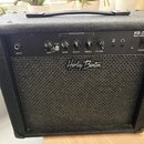 Černý basový kombozesilovač s texturovaným povrchem a černou tkanicovou mřížkou. Na horním ovládacím panelu je nápis HB-20B Bass Amplifier a logo Har…