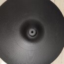Černý činely s koncentrickými drážkami po celém povrchu. Na pravé straně je vyražen nápis "Zildjian". Nástroj leží na světlém dřevěném povrchu.