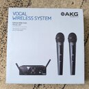 Fotografie krabice od bezdrátového mikrofonního systému. Na obalu je nápis VOCAL WIRELESS SYSTEM, WMS40 MINI DUAL VOCAL SET a logo AKG by HARMAN. Je…