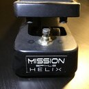 Černý expresní pedál z kovu s gumovou plochou na šlapadle. Na přední straně je bílý nápis MISSION, SP1-L6 a HELIX. Povrch pedálu vykazuje drobné neči…