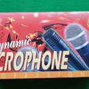 Kartonová krabice s nápisem Dynamic MICROPHONE PROFESSIONAL. Na povrchu je zobrazeno tři dynamická mikrofony v různých barvách (černý, stříbrný a tma…
