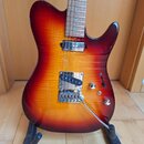 Elektrická kytara s trupem v červeno-žlutém sunburst provedení a viditnou strukturou dřeva. Nástroj má dva snímače typu humbucker, chromovaný most s…