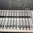 Digitální mixážní pult stříbrné a černé barvy. Na horním černém panelu je nápis YAMAHA a model TF3, dále displej a ovládací prvky. Spodní stříbrná čá…