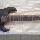Černá elektrická kytara s matným povrchem a viditnou strukturou dřeva. Na hlavě hmatníku je nápis "Hardy Martin". Nástroj má dva humbuckery, tři ovlá…