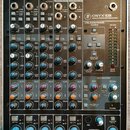 Fotografie znázorňuje míchací pult s černým šasi a kovovými ovládacími prvky. Na přístroji je vidět nápis ONYX-820i PREMIUM FIREWIRE RECORDING MIXER.…