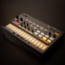 Černý kompaktní drum machine s bílými podsvícenými pady. Na přístroji je vidět logo KORG a nápis volca beats. Zařízení obsahuje několik ovládacích kn…