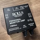Černý osobní monitorovací zesilovač s bílými nápisy. Na horní straně je logo ROLLS a text MADE IN THE USA www.rolls.com, dále označení PERSONAL MONIT…