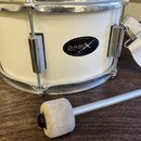 Bílý buben s chromovaným obručováním a napínacími šrouby. Na korpusu je černý oválný štítek s nápisem BASIX DRUMS. K nástroji patří bílý textilní pop…