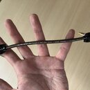 Černý instrumentální kabel s pleteným obalem, který drží v dlani. Na konektorech je bílý nápis Hicon. Podél kabelu běží bílý text: SC-THE SPIRIT XS •…