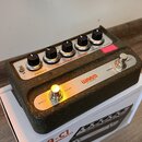 Efektový pedál v kovovém šasi s texturovaným povrchem a stříbrným horním panelem. Na panelu jsou nápisy Warm Chorus Vibrato, WAARM AUDIO a přepínače…