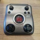 Stříbrný efektový pedál pro kytaru s nápisy GUITAR EFFECTS PEDAL a G1. Uprostřed se nachází červené digitální displej s číslicemi 8.8 a ovládacími tl…