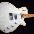 Bílá elektrická kytara s velkým pickguardem z perleťového materiálu. Na těle je v horní části viditelné logo "Gretsch". Nástroj má dva snímače, tři o…