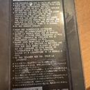 Fotografie detailu zadní strany zařízení s technickými specifikacemi v angličtině, francouzštině a japonštině. Je zde uveden nápis DC-9V AC ADAPTOR E…