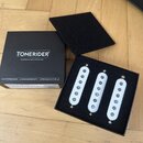 Černá krabice s nápisem TONERIDER GUITAR & BASS PICKUPS obsahuje tři bílé snímače s kovovými polosněma. Na spodní části krabice jsou texty SCATTERWOU…