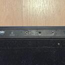 Detail zadní strany modrého zařízení s nápisem Warwick GIGBOARD RB 23110. Na panelu se nachází tlačítko POWER a pět konektorů pro napájení s označení…