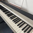 Digitální piano stříbrné barvy s černými a bílými klávesami. Na pravé straně korpusu je nápis SP300. Horní část nástroje obsahuje ovládací panel s tl…